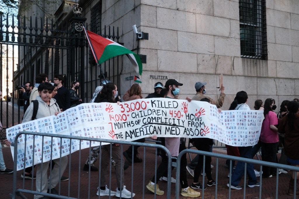 Protesters hold a banner outside Pulitzer Hall at Columbia University