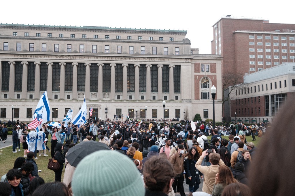 Israeli flags wave among a large crowd on Columbia&rsquo;s campus with Butler Library in the background