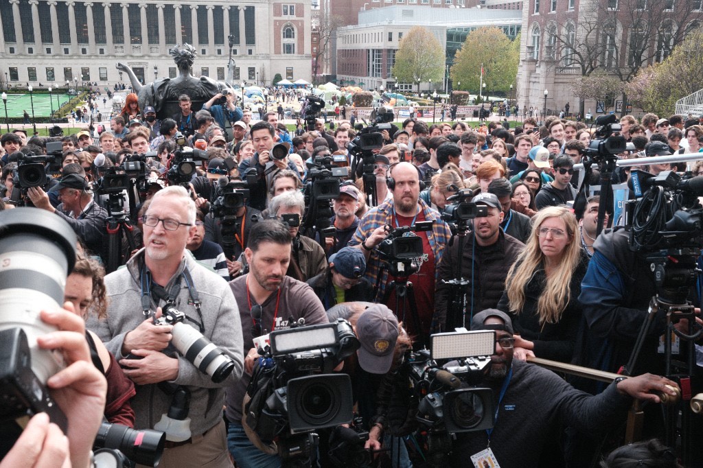 A massive crowd of journalists with cameras and video equipment on Columbia&rsquo;s campus